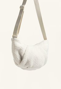 Borsa a spalla bianca in finta shearling con forma arrotondata, tracolla beige regolabile e tessuto testurizzato per maggiore profondità.