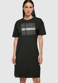 Czarna bawełniana sukienka t-shirtowa z krótkimi rękawami, okrągłym dekoltem i powtarzającym się napisem "SAN FRANCISCO" w różnych odcieniach szarości i bieli.