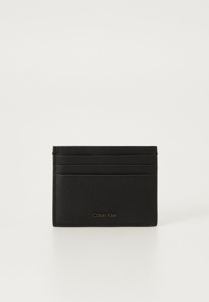 Svart lær kortholder med teksturert finish, flere kortholdere og et debossed Calvin Klein-logo foran.