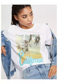 Biała bawełniana koszulka z graficznym nadrukiem palm i plaży w pastelowych kolorach, z napisem "California" w turkusowych literach.
