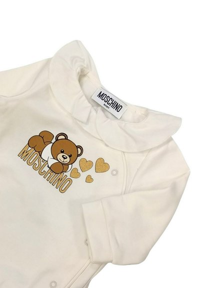 Body bianco per neonato con colletto a costine, caratterizzato da una grafica di un orso marrone e dettagli a forma di cuore dorati, etichettato 'MOSCHINO BABY' con caratteri in grassetto.