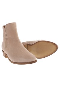 Beiga mockaskor med spetsig tå, låg blockklack och slät yta. Inkluderar en sidodragkedja för enkel påtagning.