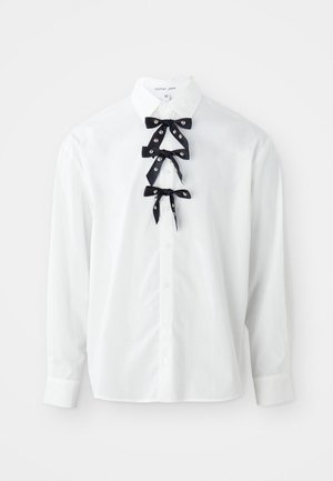 White button-up shirt in cotton with long sleeves. Features three black satin bows with silver accents at the neck. Size medium.