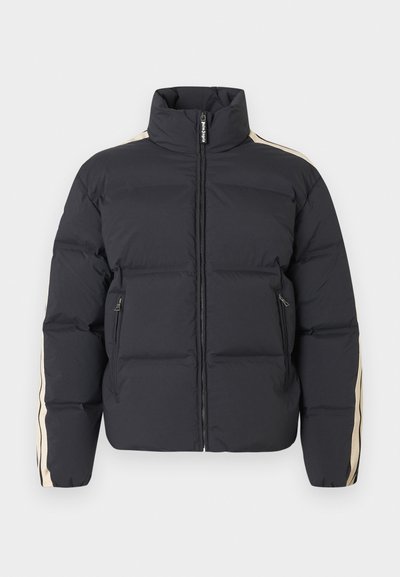 Μπουφάν από καπιτονέ ύφασμα σε σκούρο μπλε ναυτικό χρώμα με ψηλό γιακά, φερμουάρ και μπεζ ρίγες στα πλάγια. Διαθέτει δύο μπροστινές τσέπες με φερμουάρ και υφή με καπιτονέ ραφές.