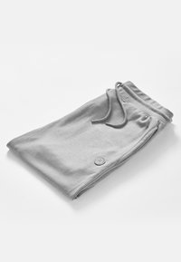 Grå sweatpants lavet af blødt stof, med en snoretræk i taljen, sidesømme og et rundt logo-patch på benet.