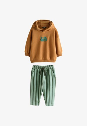 Braune Kapuzenjacke mit dem Schriftzug "Cool Vibes" in Türkis, kombiniert mit grün gestreiften Jogginghosen mit elastischem Bund und seitlichen Taschen.