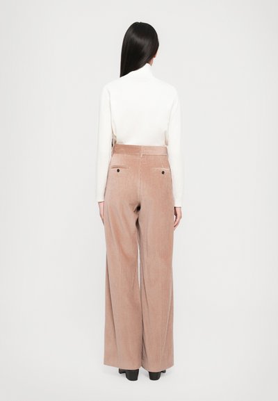 Hellbraune Cordhosen mit weitem Bein und hoher Taille, die vertikale Rippung und zwei Gesäßtaschen aufweisen. Glatte Textur und lässige Passform.