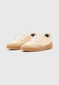 Sneakers beige in materiali mesh e suede, punta arrotondata e suola in gomma. Presentano lacci e dettagli di cucitura tono su tono.