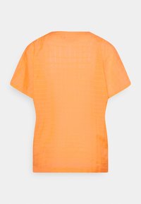 Top arancione a maniche corte in un tessuto leggero con texture a griglia quadrata e scollo rotondo, caratterizzato da una vestibilità comoda e orlo pulito.