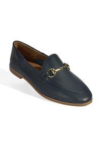 Mocassins en cuir navy avec un bout arrondi, détail en métal doré sur le devant et une semelle en caoutchouc beige. Texture lisse, design minimaliste.