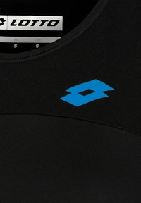 Top deportivo negro con el logo azul de Lotto. La tela parece suave, con un escote redondo y un diseño ajustado. Etiqueta de tamaño visible.