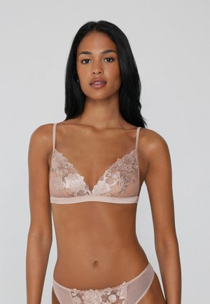 Bralette en dentelle nude doux avec broderie florale, bonnets triangulaires, bretelles ajustables et bande lisse. Texture délicate et transparente.