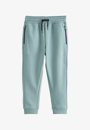 Svetlomodré teplákové nohavice z mäkkej látky s elastickým pásom, šnúrkou na stiahnutie a čiernymi zipsovými bočnými vreckami. Strečové manžety na členkoch.