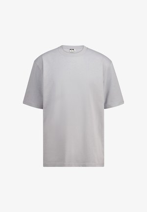 Camiseta de manga corta gris claro, hecha de algodón suave. Diseño clásico de cuello redondo con un ajuste relajado y sin patrones ni acentos visibles.