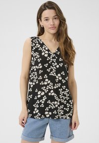 Haut sans manches floral noir avec décolleté en V, orné de fleurs blanches et roses, en tissu léger et à coupe décontractée, associé à un short en denim.
