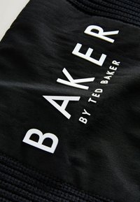 Tessuto nero con bold bianco testo, "BAKER by TED BAKER," con texture in rilievo. Design semplice senza ulteriori motivi.