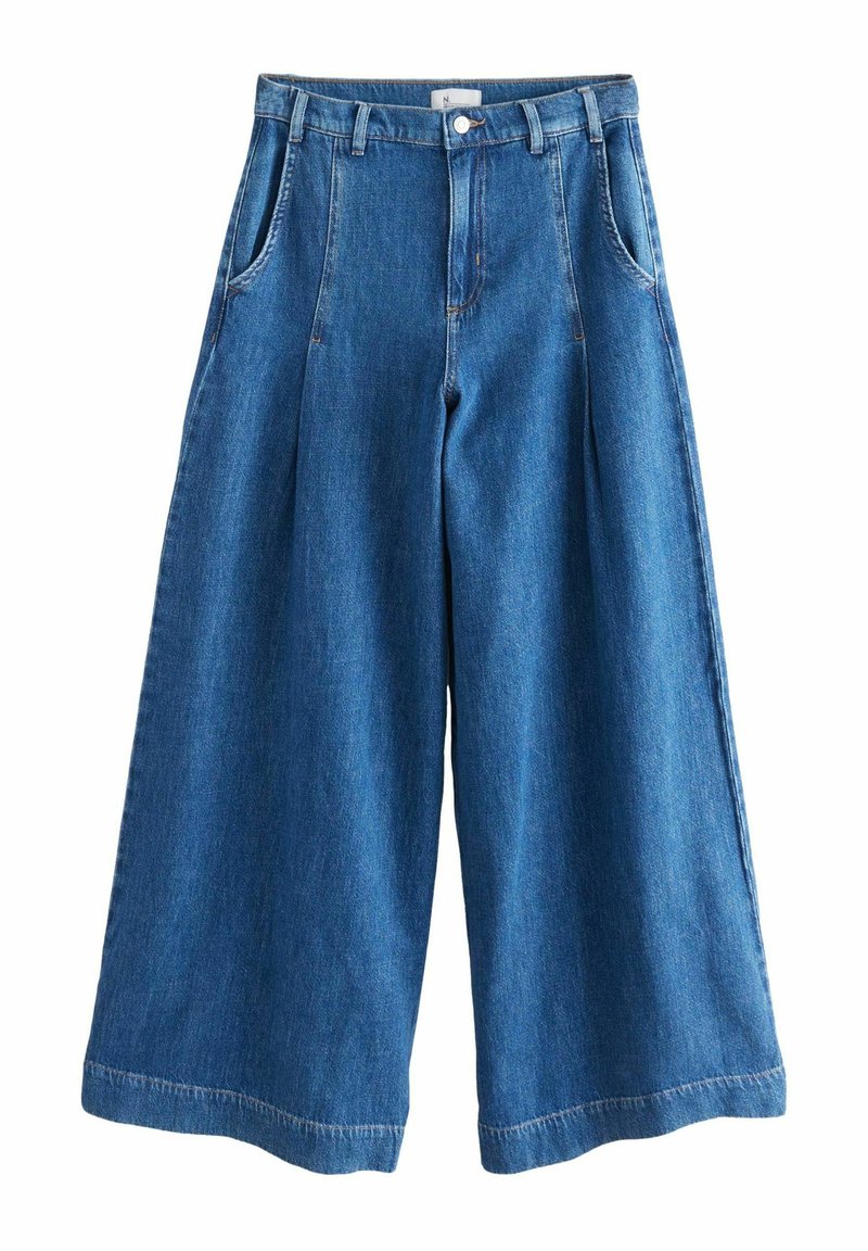 Laia denim püksid tumesinisest kangast, kõrge vöökohaga, volditud, vöökoharihmade ja kahe küljetaskuga. Sile tekstuur ja korralik õmblus.