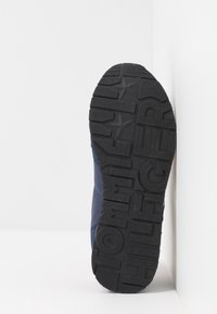 Blå atletisk sko med en strukturerad svart gummisula. Har "TOMMY HILFIGER" präglat på sulan. Slät ovandel med minimala accenter.