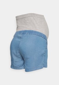 Maternity denim shorts featuring a light blue cotton fabric, gray jersey belly band, elastic waistband, and a relaxed fit.