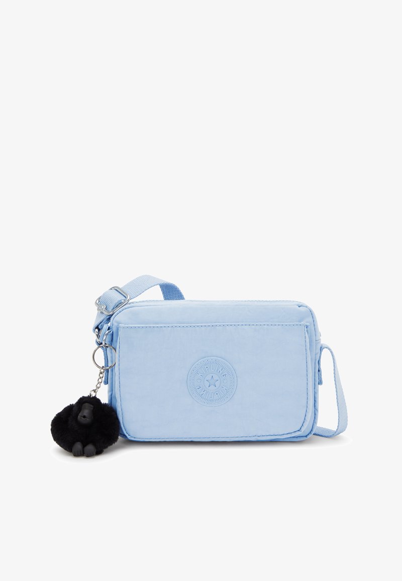 Borsa rettangolare di colore blu chiaro realizzata in tessuto, con una toppa rotonda del logo, chiusura con zip e un portachiavi a forma di gorilla nero.