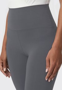 Szare legginsy z wysokim stanem wykonane z elastycznej tkaniny, charakteryzujące się gładką teksturą i dopasowanym krojem, z bezszwowym pasem.