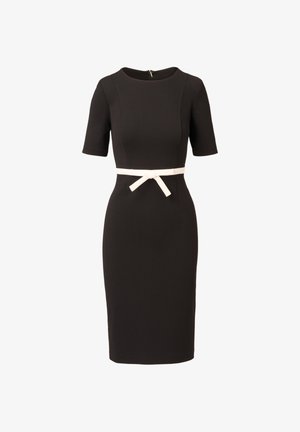 Černé šaty délky po kolena s krátkými rukávy a bílým pásem zavázaným na mašli v pase, mají kulatý výstřih a zadní zip.