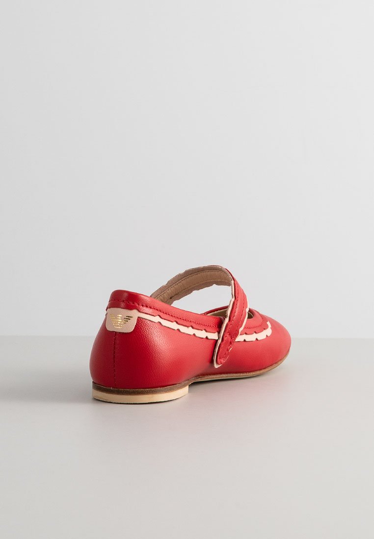 Scarpa piatta in pelle rossa con punta arrotondata, design ondulato, una singola fascetta attraversante il dorso del piede e un piccolo logo dorato sulla parte posteriore.