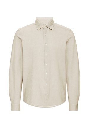 Garām piedurknēm bēša krekls ar teksturētu rakstu, pogājamu apkakli un priekšpuses pogu aizdari. Raksturīgs apaļš apakšmala un pieguloši aproces.