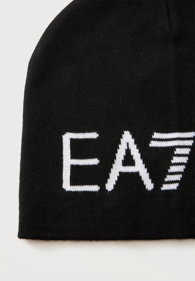 Bonnet tricoté noir affichant un texte blanc partiel "EA7" avec le numéro 7 présentant des rayures horizontales sur un fond uni.
