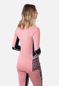 Langermige sporttop in het roze met marineblauwe accenten, voorzien van een geometrisch patroon aan de zijkant, gemaakt van rekbare, ademende stof.