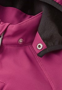 Col haut en fuchsia avec une doublure noire, présentant des boutons-pression en métal et une texture de tissu lisse. Gros plan sur les détails de couture et de quincaillerie.