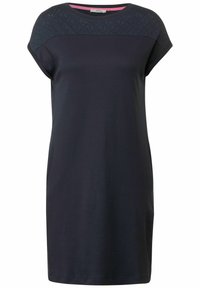 Laivaston mekko lyhyillä hihoilla, tekstuurilla varustettu yoke, sileä kangas ja suora leikkaus. Sisältää vaaleanpunaisen sisäkauluksen yksityiskohdan.