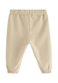 Beige mjukisbyxor med elastisk midja och rynkade muddar, gjorda av mjukt material och med en enkel design och slät yta.