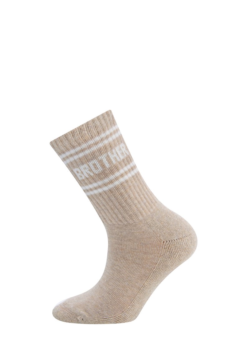 Beżowe skarpetki crew o prążkowanej fakturze, z białym napisem "BRAT" i dwoma białymi paskami u góry. Elastyczny materiał z mieszanki bawełny.
