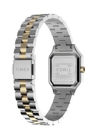 Montre Timex avec un bracelet en acier inoxydable argenté et doré, un boîtier octogonal, et un cadran clair affichant le logo de la marque et les détails.