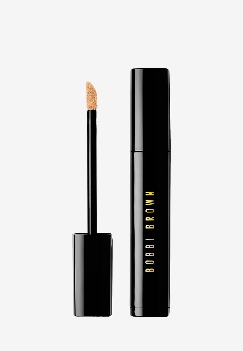 Bobbi Brown flytende concealer i et sylinderformet svart rør med gullbokstaver. Har en doe-foot applikator for presis påføring.