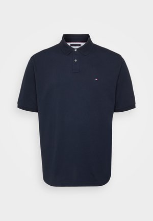 Navy blue polo shirt made of cotton, featuring a two-button placket and a small logo on the left chest. Short sleeves, straight hem.