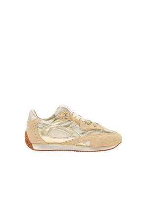 Baskets basses beige et or avec accents en daim, panneaux latéraux texturés, lacets beiges, et semelle en caoutchouc marron.