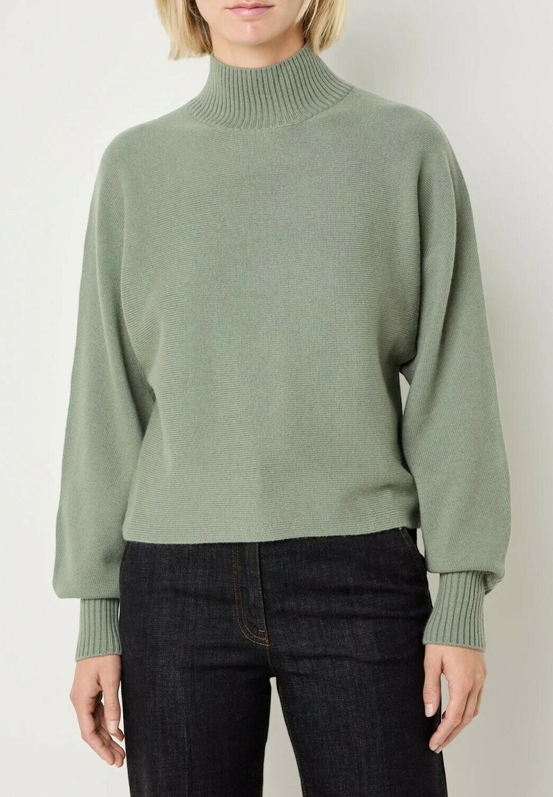Maglione pullover verde menta con un alto colletto a coste, spalle cadenti e polsini a coste. Texture liscia con una vestibilità leggermente ampia.