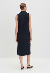 Marineblaues, ärmelloses Kleid mit kragenförmigem Ausschnitt, geradem Schnitt und Midi-Länge. Kombiniert mit schwarzen Slingback-Absatzschuhen, schlichtem Design.
