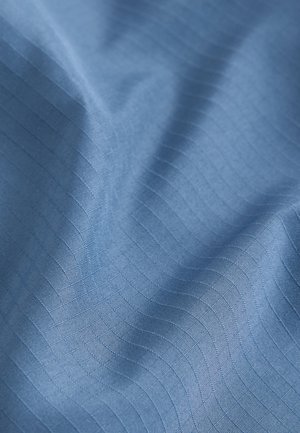 Tela textil de color azul claro, con una textura suave y patrones sutiles acanalados que recorren horizontalmente la superficie.