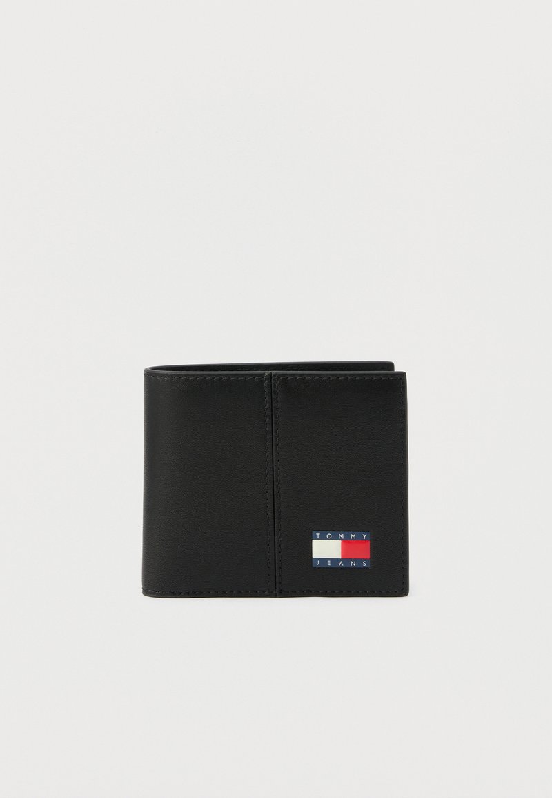 Μαύρο δίπτυχο πορτοφόλι με ραμμένες άκρες και μικρό λογότυπο Tommy Jeans σε κόκκινο, λευκό και μπλε στην κάτω δεξιά γωνία.