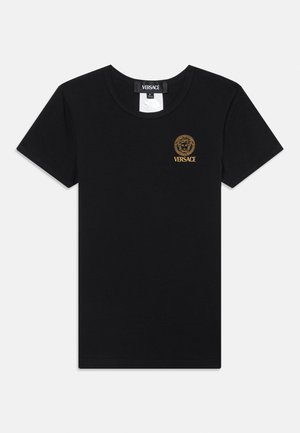 Camiseta de algodón negra de manga corta, con cuello redondo y logo de Versace en relieve dorado que presenta la cabeza de un león en el lado izquierdo del pecho.