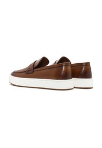 Zapatos de cuero marrón tipo slip-on con un acabado texturizado, suela de goma blanca y un perfil bajo. Presentan una costura decorativa en la parte superior.