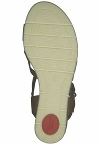 Brown sandal sole featuring a textured rubber bottom with a wavy pattern, white midsole, and a red circular accent labeled "Tommy's Comfort."
