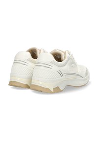 Vita atletiska skor har en texturerad ovandel med meshdetaljer, vadderad krage och krämfärgade gummisulor, vilket framhäver en strömlinjeformad design.