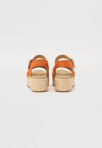 Oransje plattform sandaler med ankelstropper, vevd jute-mellomsåle og glatt lær øvre del. Spenne detalj og åpen bakdesign.