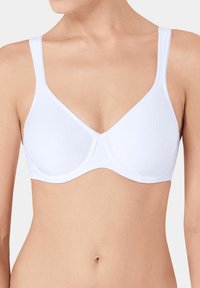 Soutien-gorge blanc avec bonnets moulés, bretelles ajustables et texture lisse. Design simple sans motifs visibles ni détails en métal.