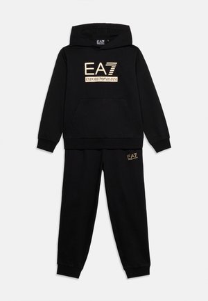 Musta hupullinen collegepaita ja vastaavat housut, joissa kultainen EA7 Emporio Armani -logo rinnassa ja reidessä, esitettynä tasaisesti valkoisella taustalla.