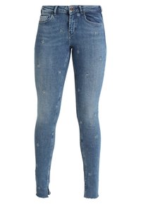 Smal jeans i ljusblå denim, med små broderade blommönster. Slitna detaljer vid fållarna; hög midja med standardfickor.